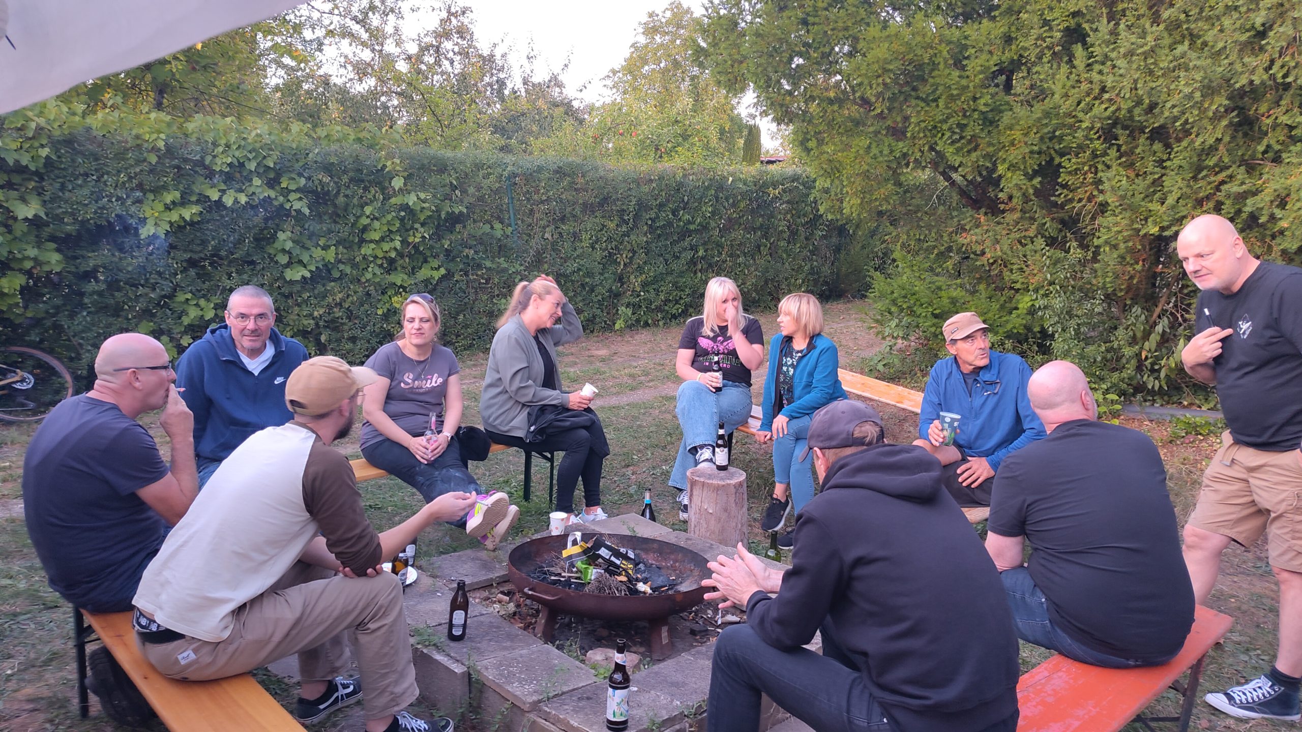 Mitglieder und Familien sitzen gemeinsam beim Sommerfest im Garten